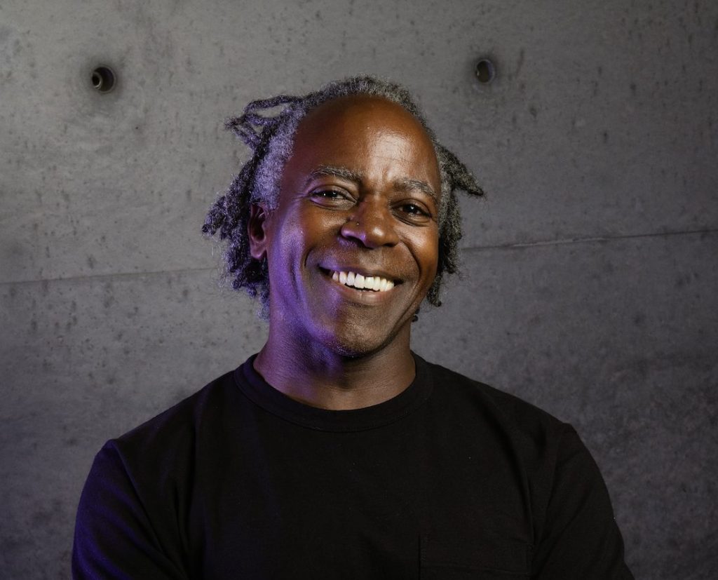 Photo of Arnold Kemp in black T-shirt smiling.