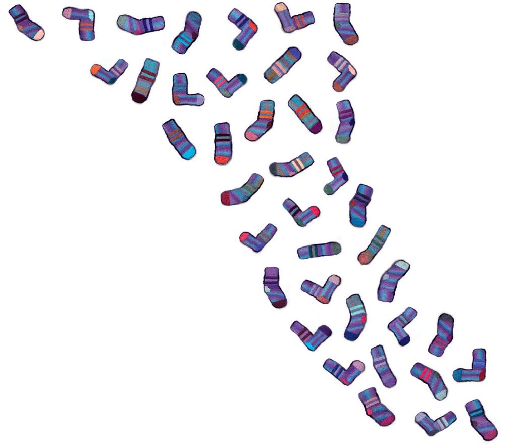 Dozens of colorful, patterned socks are scattered in a loose, curved line on a white background, creating a dynamic, swirling visual effect.